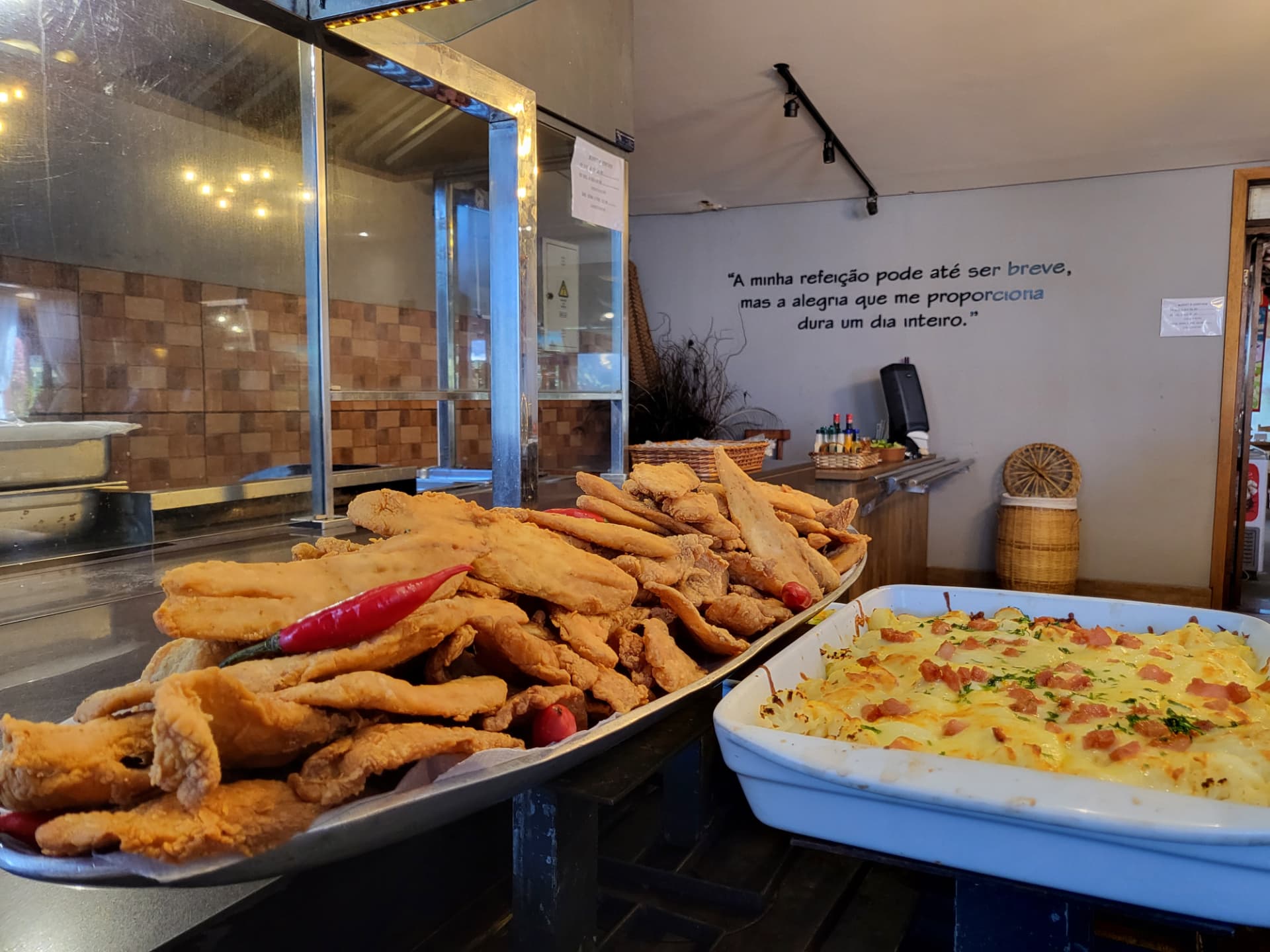 Buffet do Fried Fish Vilarejo com filés dourados e cassoulet cremoso sobre bancada escura